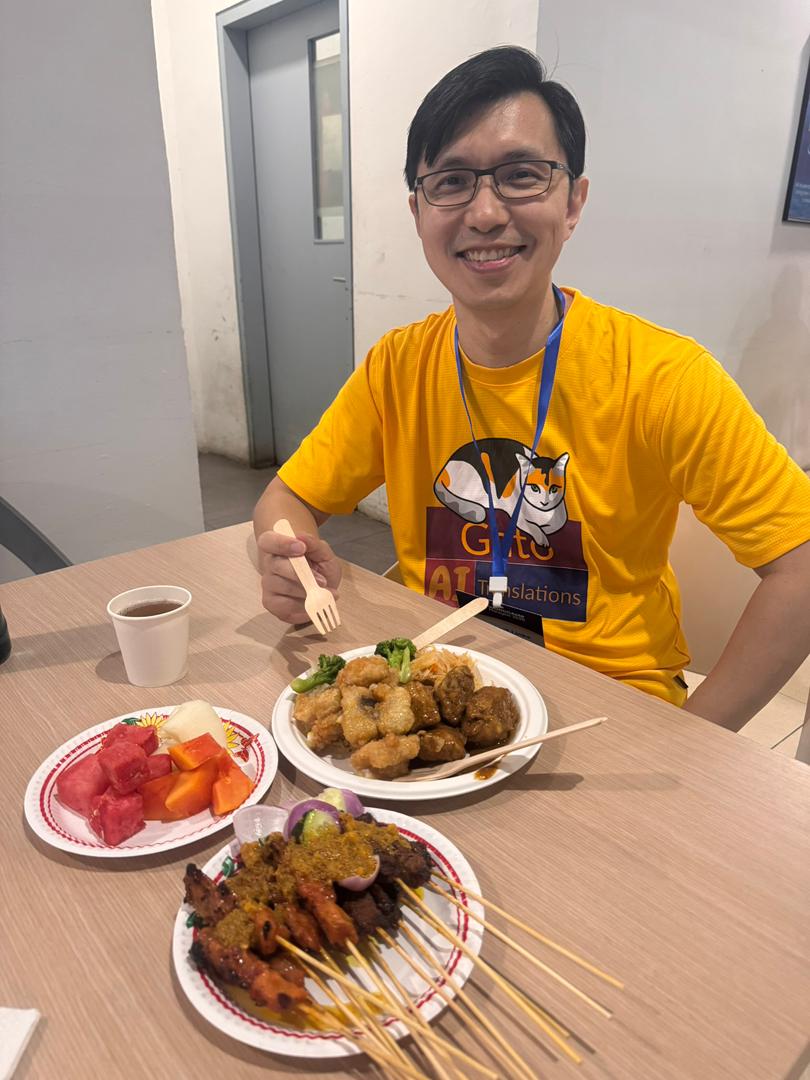 David Wang, amigo do Gato, saboreando satay no WordCamp Malaysia 2025